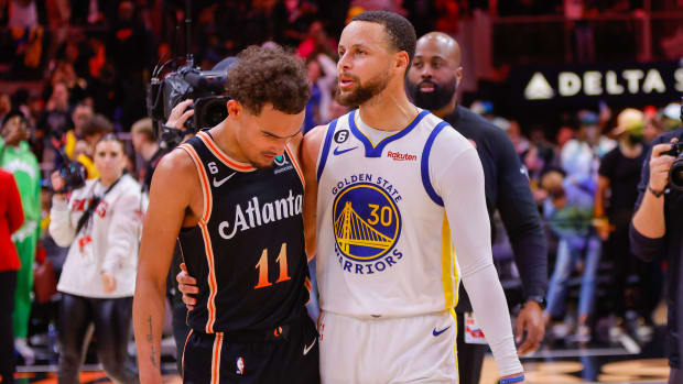 Trae Young talks to Stephen Curry after a game.